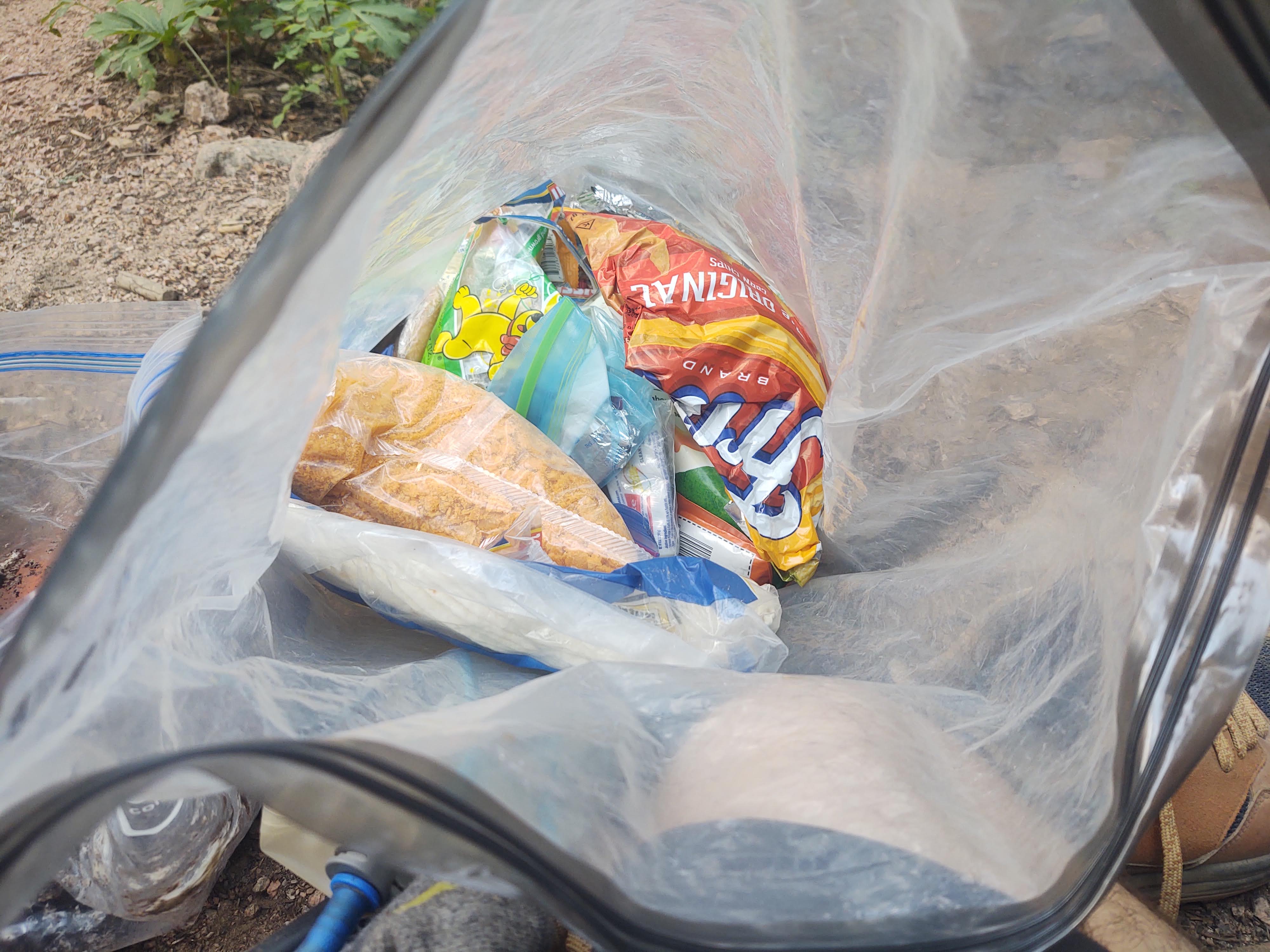 Trail resupply food including Fritos and crackers packed in a dry bag